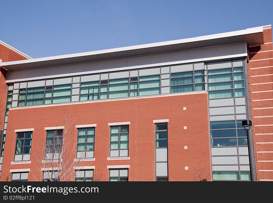 Modern Brick And Glass Building With Blue Sky Back