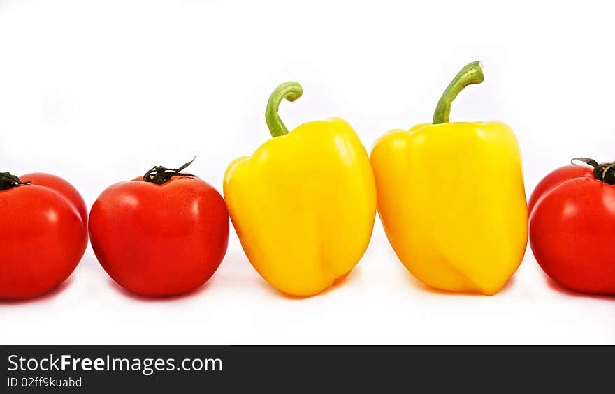 Fresh tomatoes and yellow peppers in a row on white bacground. Fresh tomatoes and yellow peppers in a row on white bacground