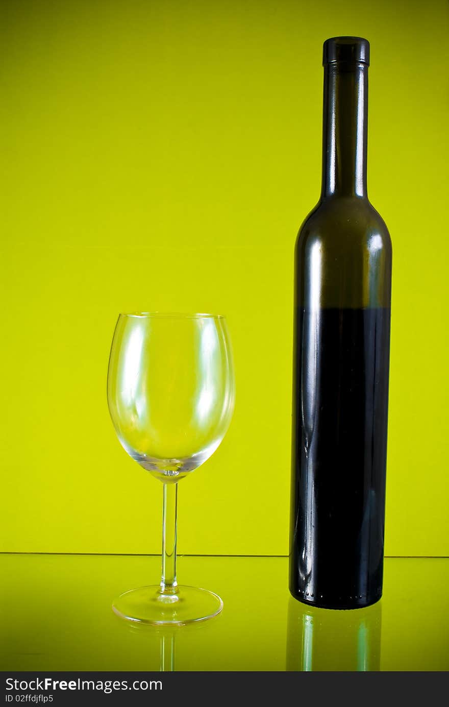 Glass, wine bottle on yellow background