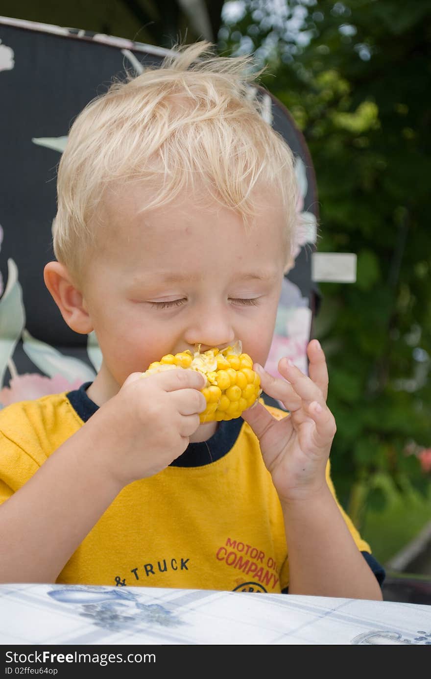 Boy eating fresh boiled corn. Boy eating fresh boiled corn