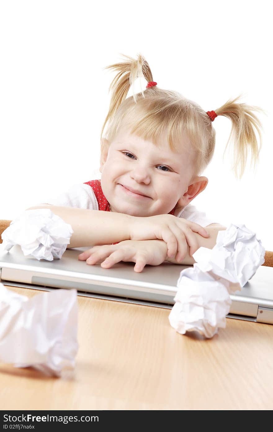 Child with crampled sheets of paper at the table