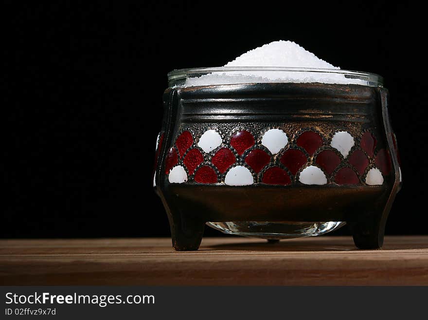 High milling salt in a saltcellar, a background - black.