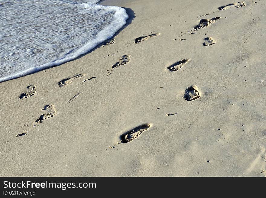 Imprint of human feet in the sand on the beach