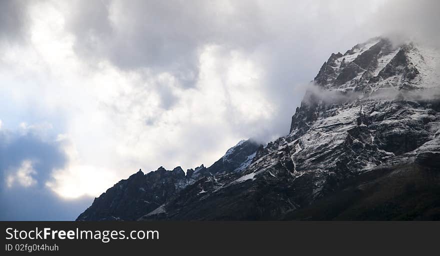 A rugged mountain cliff in Torres Del Paine NP, shrouded in mist. A rugged mountain cliff in Torres Del Paine NP, shrouded in mist.