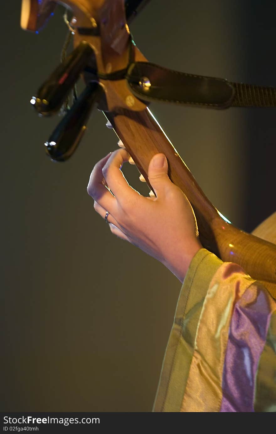 A girl is playing lute. A girl is playing lute