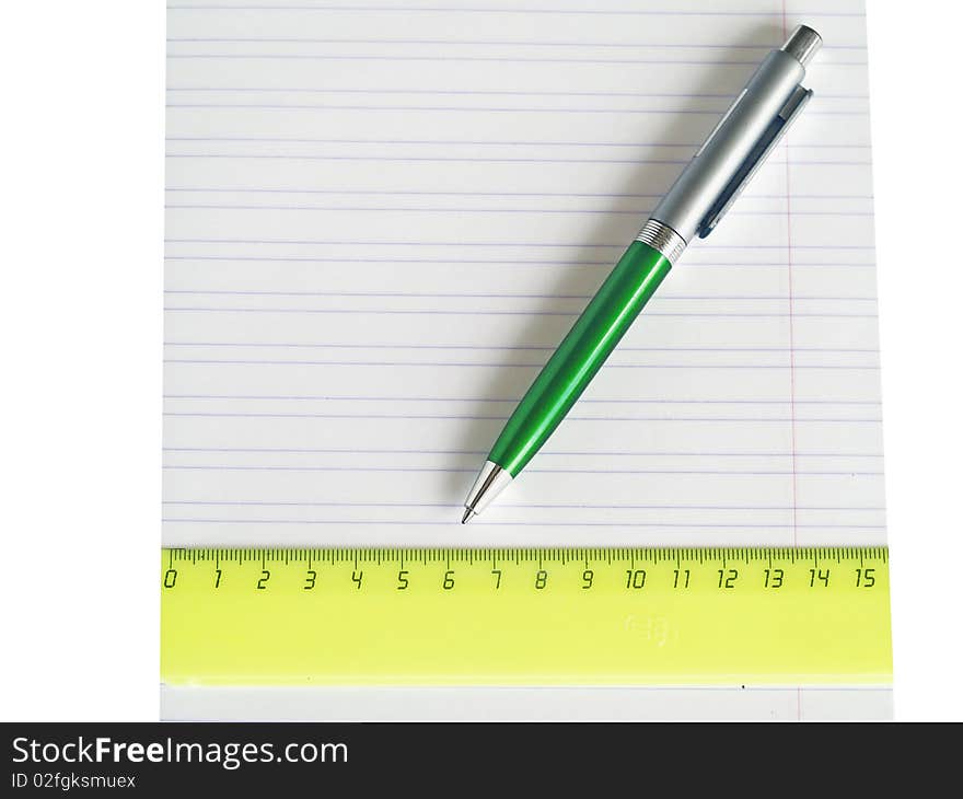 The pen and ruler lays on a school writing-book close up isolated. The pen and ruler lays on a school writing-book close up isolated