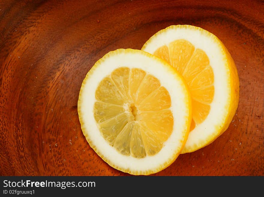 Slices of lemon on a wooden plate. Slices of lemon on a wooden plate