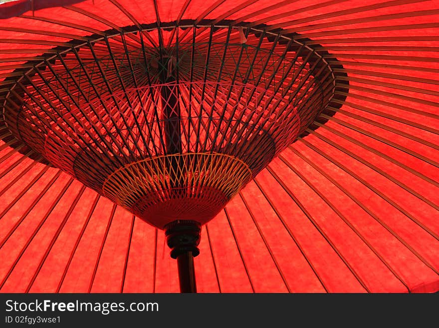 Red paper Japanese umbrella.  Red is a colour associated with Japan and East Asia. Red paper Japanese umbrella.  Red is a colour associated with Japan and East Asia.