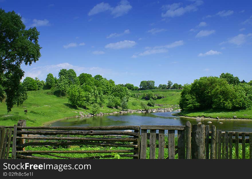 Nice village summer landscape with river and blue sky