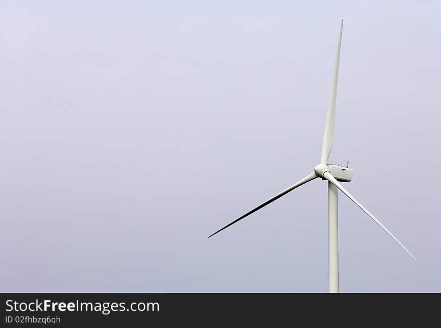 Isolated solitary windmill against a white sky and homogeneous. Isolated solitary windmill against a white sky and homogeneous