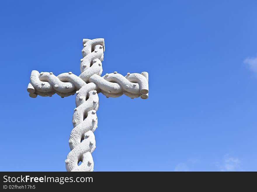 Stone cross with interlaced design over blue sky. Stone cross with interlaced design over blue sky