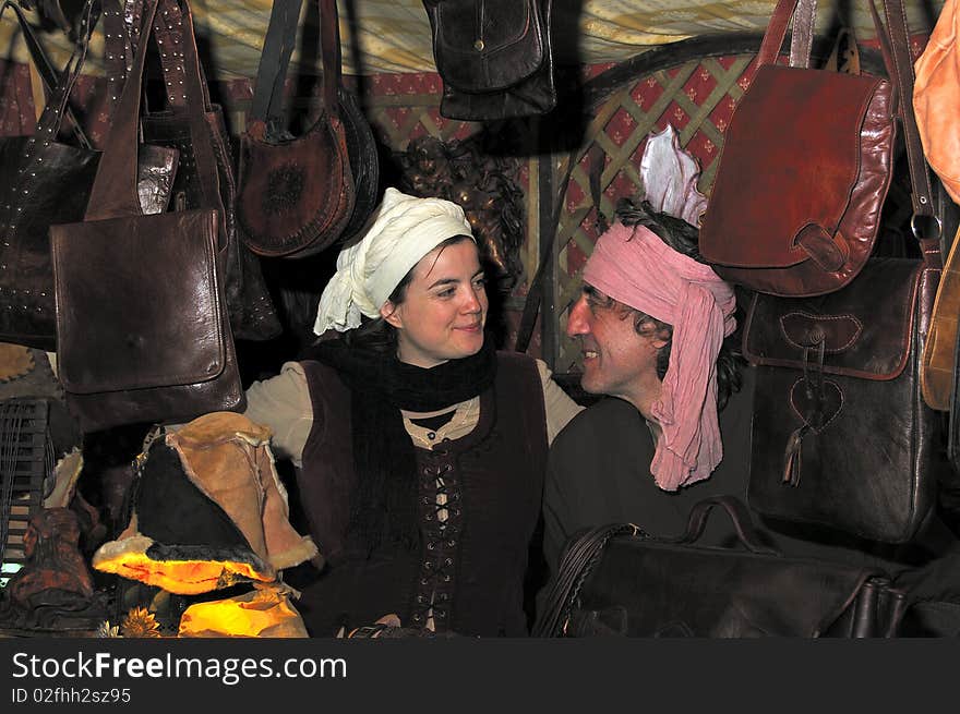 A man and woman smiling, faceing one another, surrounded by hand made leather bags. A man and woman smiling, faceing one another, surrounded by hand made leather bags.