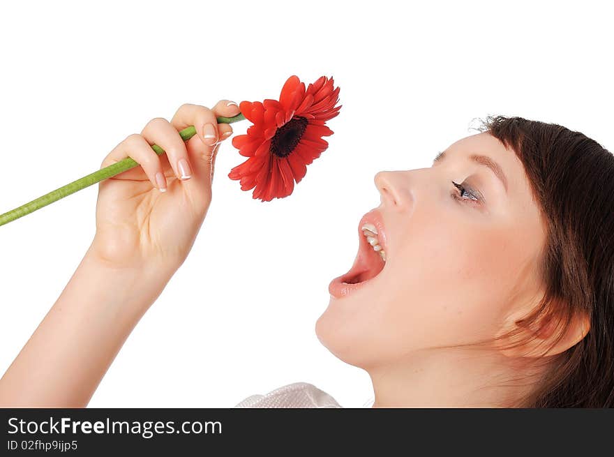 Charming young girl in blue jeans and a white blouse with a red flower in the hands