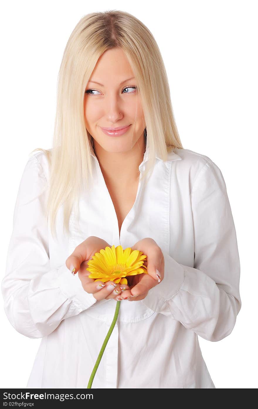 Young smiling blonde in a white shirt plays with a yellow flower in the hands