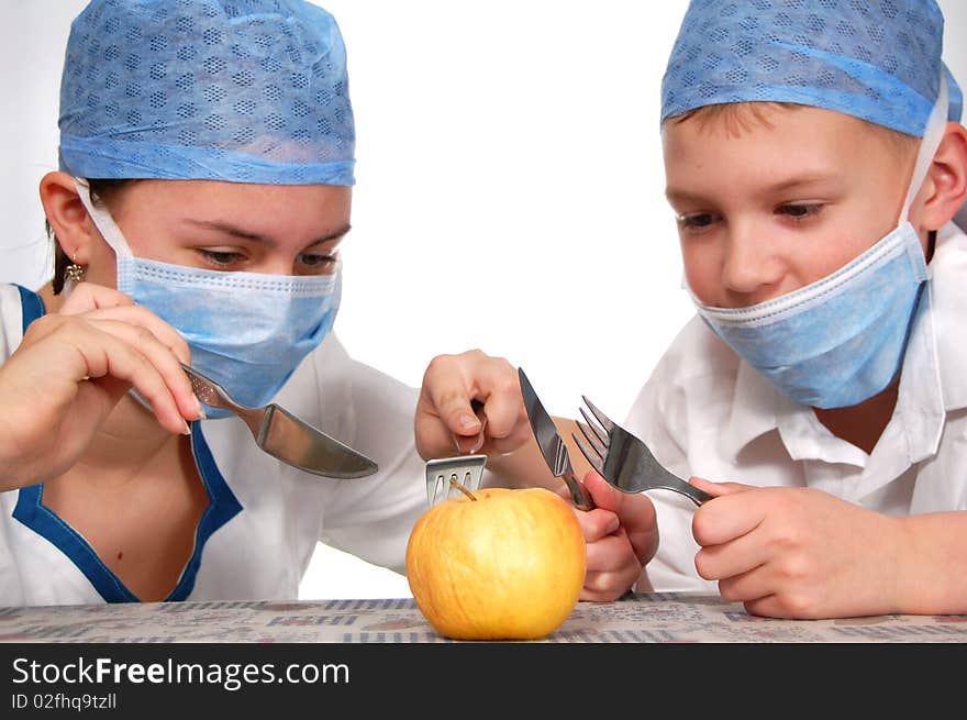 Two teens operating on a apple. Two teens operating on a apple