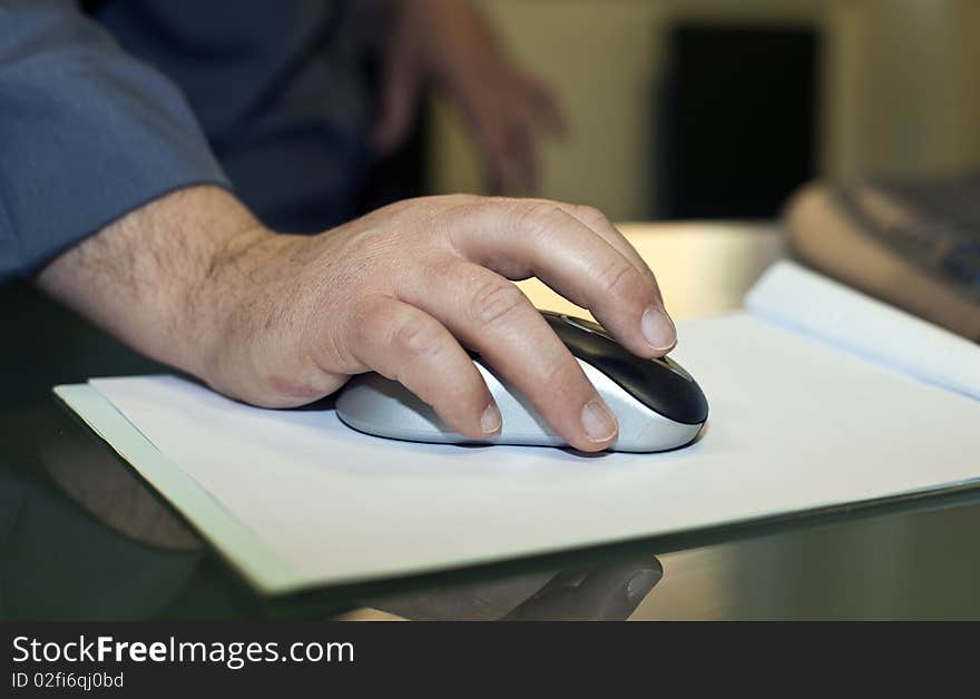 Hand on a mouse preparing a report in the meeting room. Hand on a mouse preparing a report in the meeting room