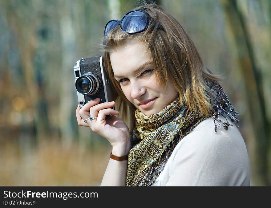 Beautiful young woman making photo using old camera. Beautiful young woman making photo using old camera