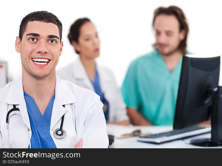 Happy young doctor in focus, two others in out of focus in white background