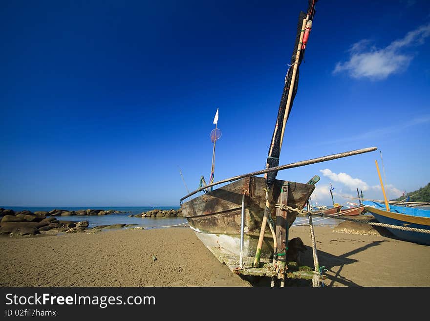 Old Row Boat on the beach with blue sky