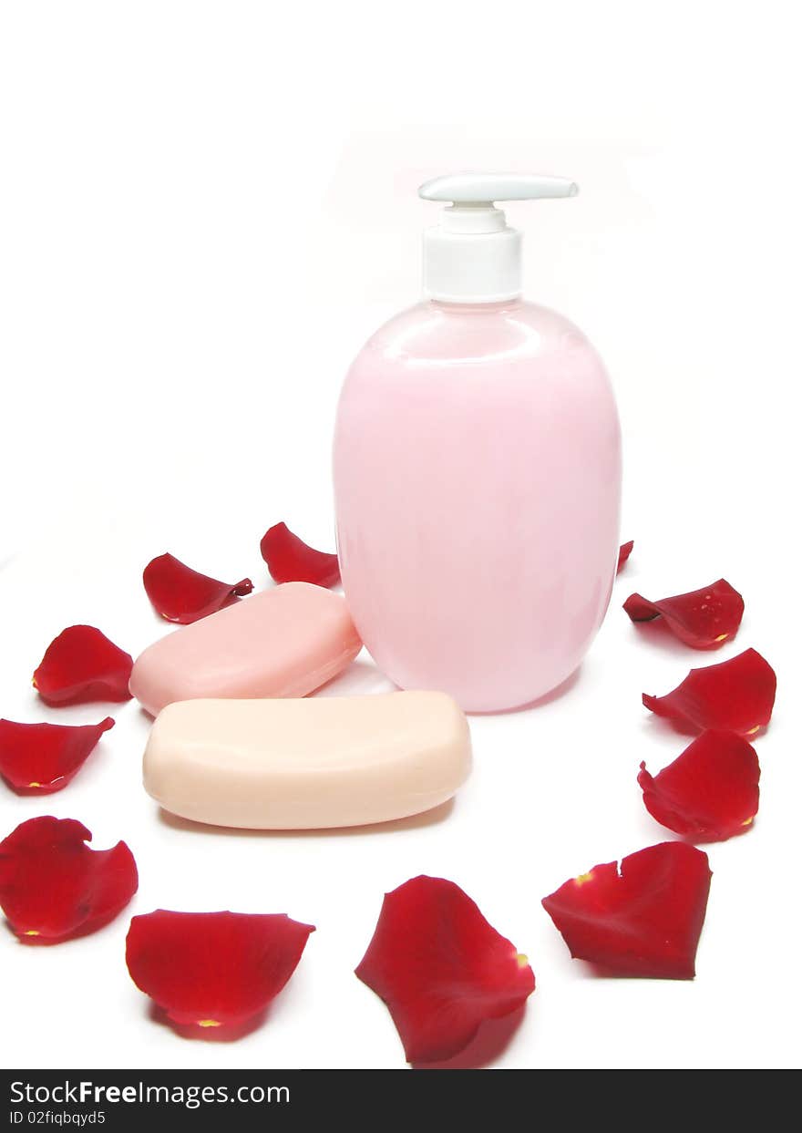 Liquid soap with rose extract and soaps among red petals