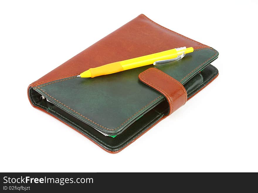 Closed leather office organizer and a yellow pen