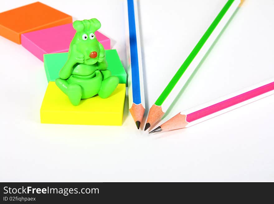 Colorful pencils, rubbers, and a funny green monster. Colorful pencils, rubbers, and a funny green monster