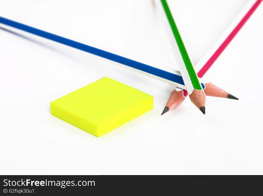 Colorful pencils crossed and yellow rubber