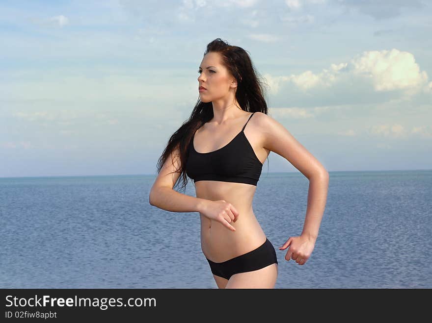 The young beautiful girl does jog on a beach