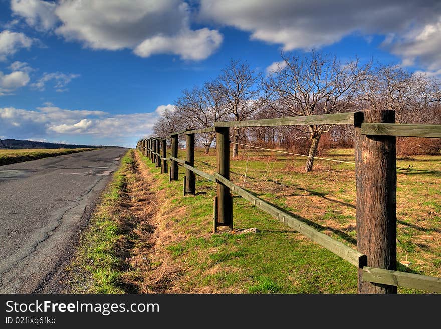 A country road next to meadow. A country road next to meadow