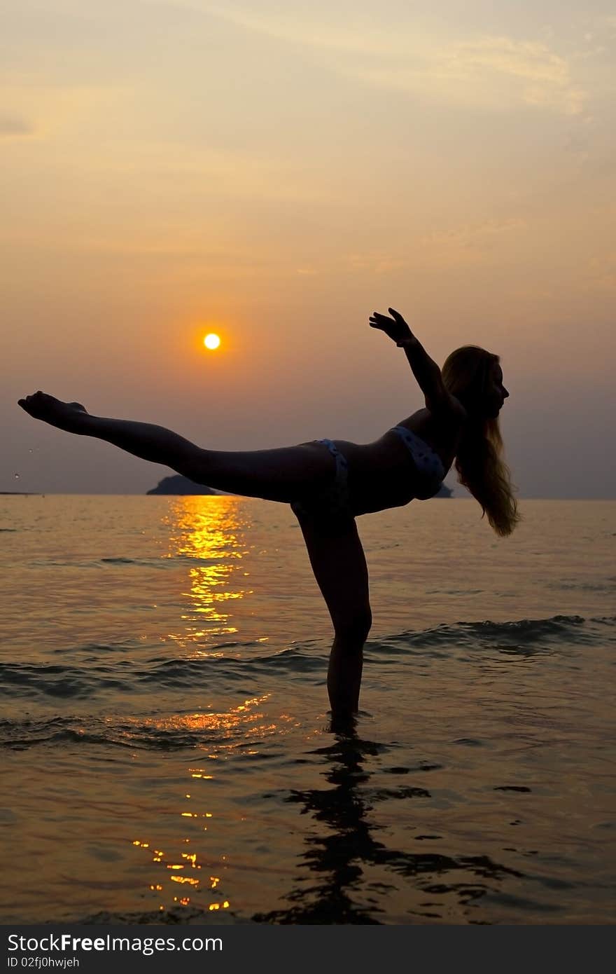 Young long hair woman on coastline at sunset time