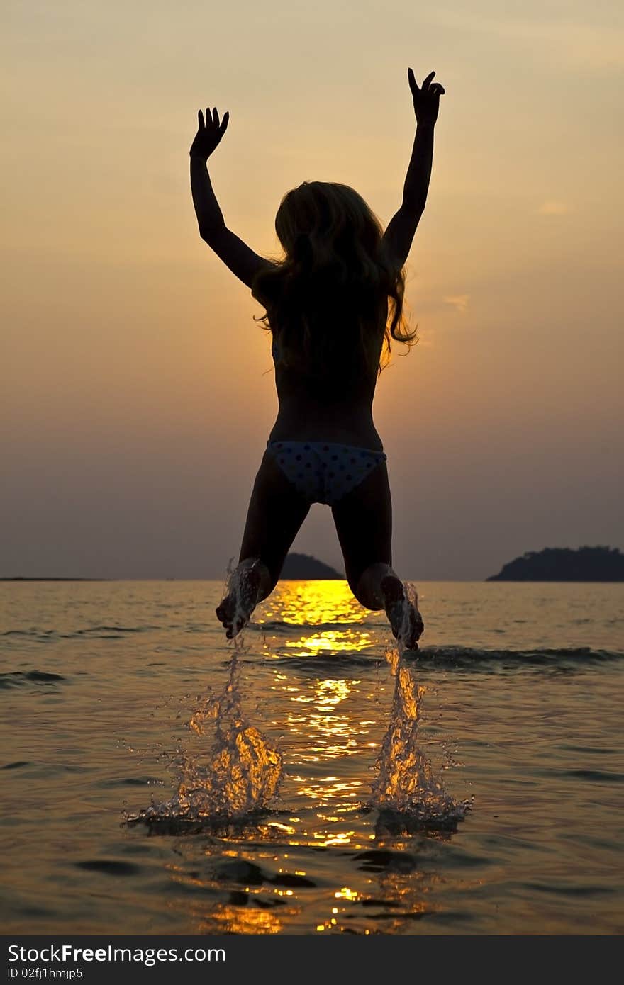 Young long hair woman on coastline at sunset time