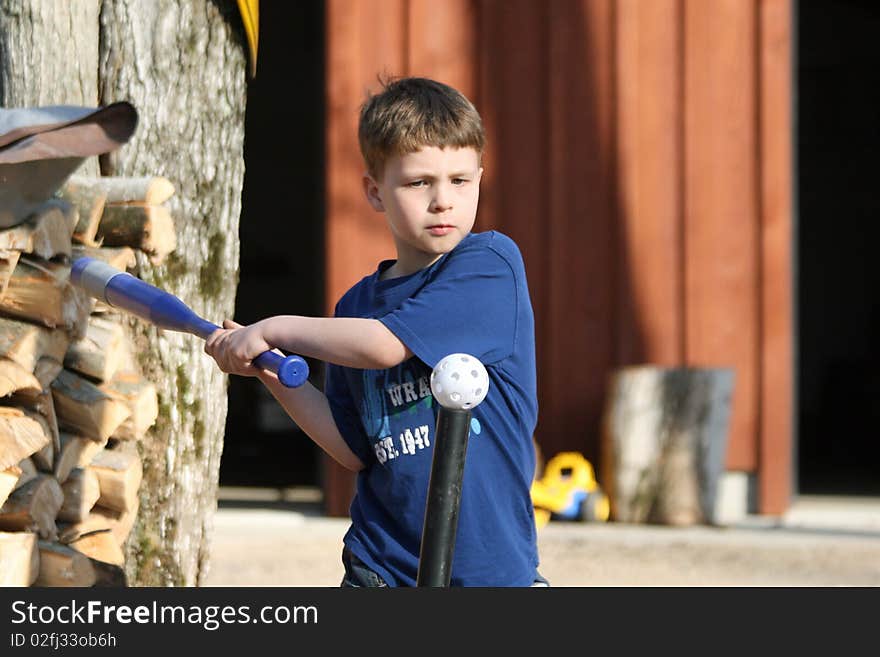 A young boy playing t-ball at home. A young boy playing t-ball at home.