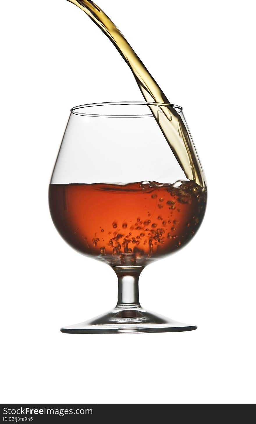 Pouring cognac brandy in glass isolated on white