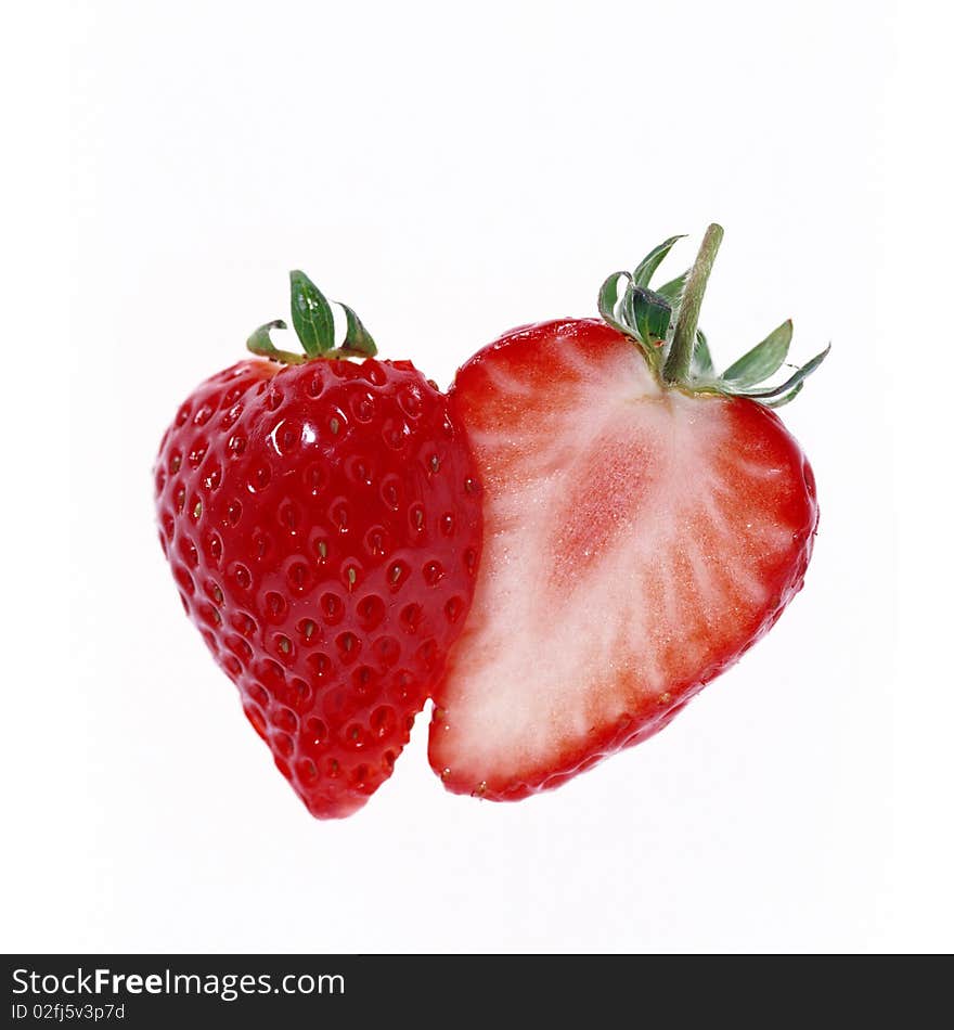 Strawberries cut in half on a white background.