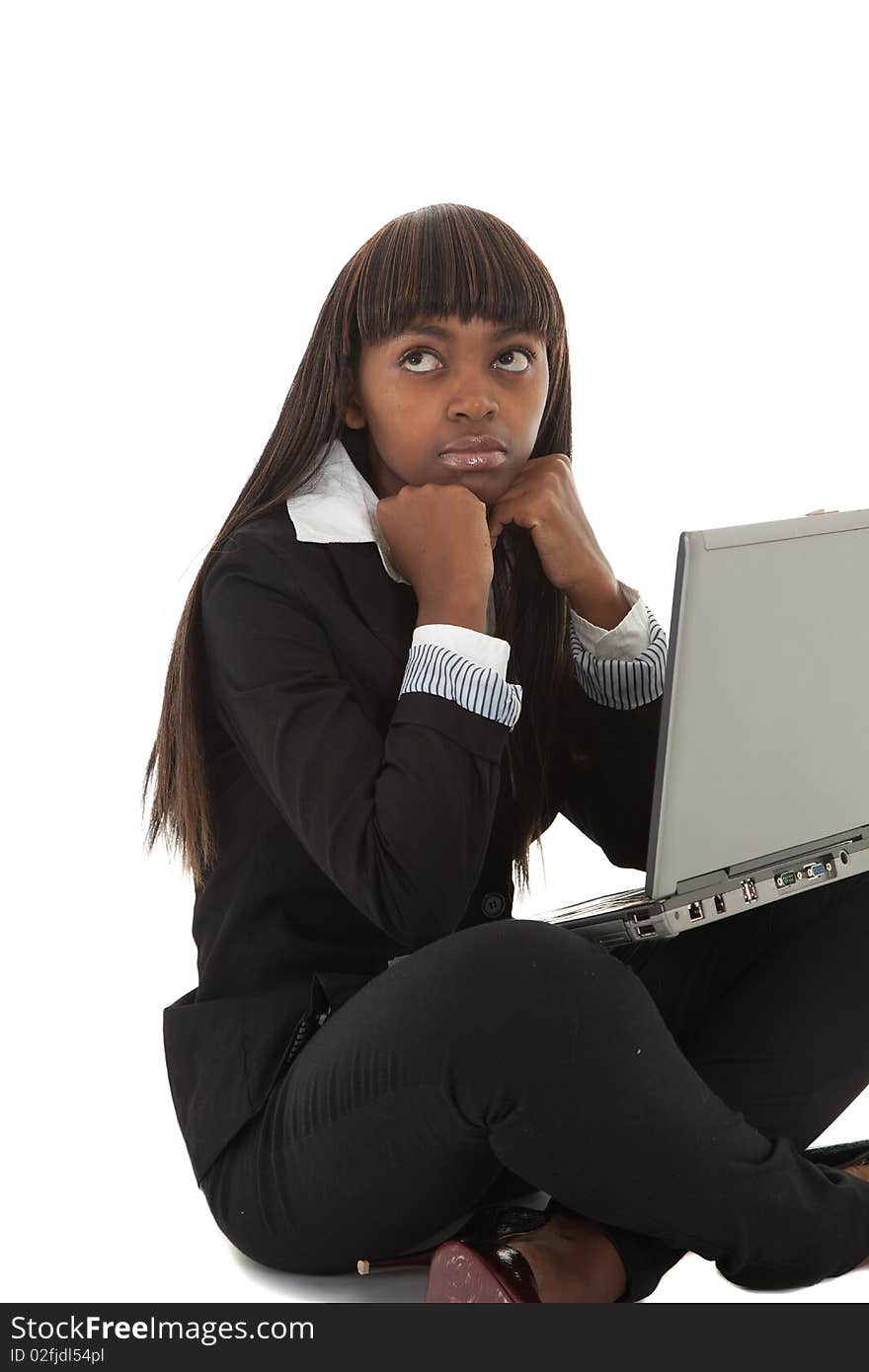 Young black female executive looking tired with face in hands on laptop