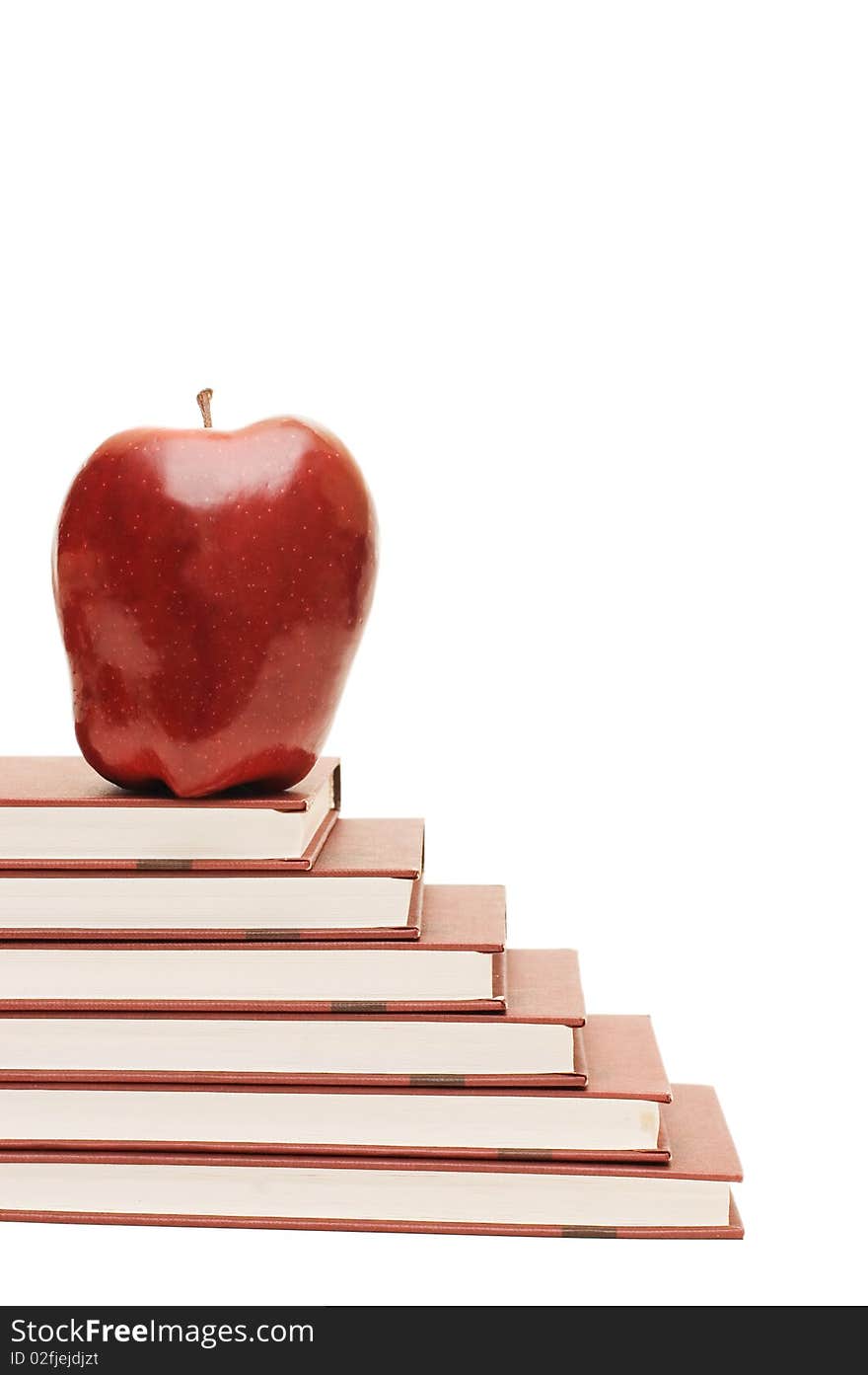 Stack of books and apple isolated over white