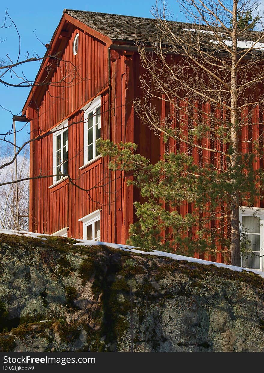 Old Finnish farm house. Rock in front of the house.