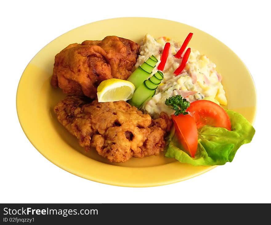 Plate of schnitzel and potato salad decorated with vegetables. Plate of schnitzel and potato salad decorated with vegetables