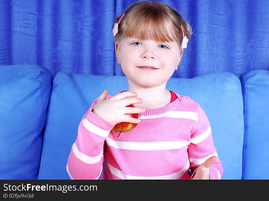 Happy girl with apple in sofa