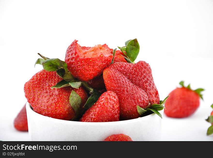 Strawberries in bowl and one with bite