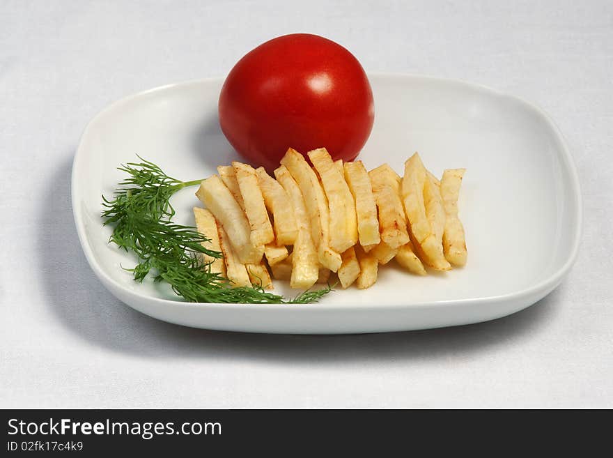 Fried potato with a tomato on a plate