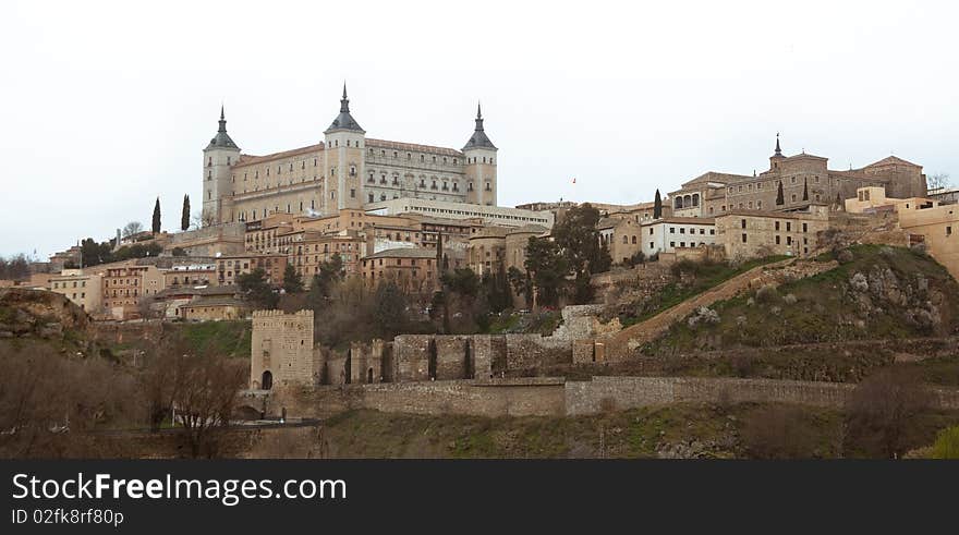 View over the rooftops of houses in Toledo Spain with fortress on a mountain top