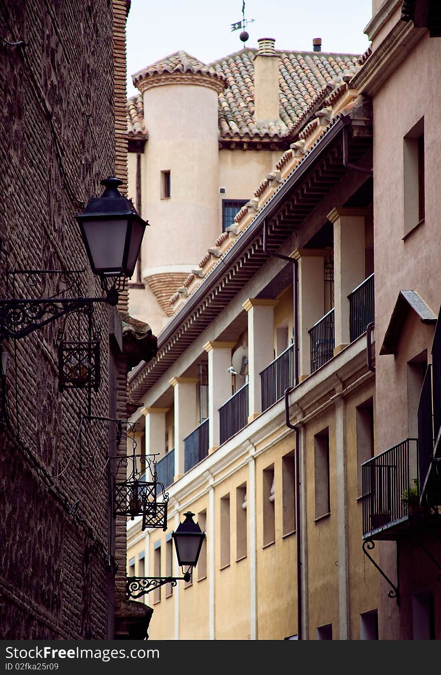 Narrow street in Toledo Spain in the summer with a lantern and windows