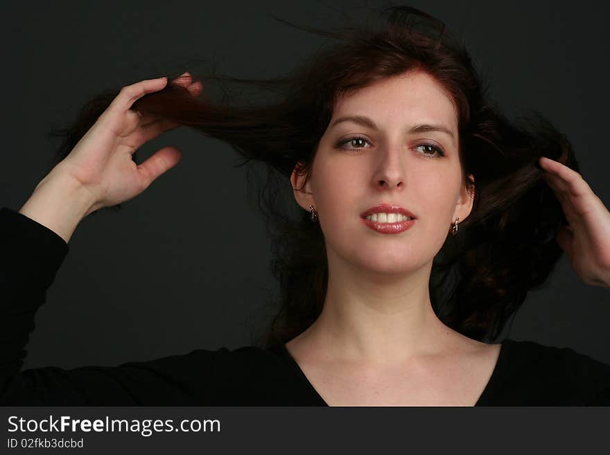 Portrait of young brunette woman isolated on black background