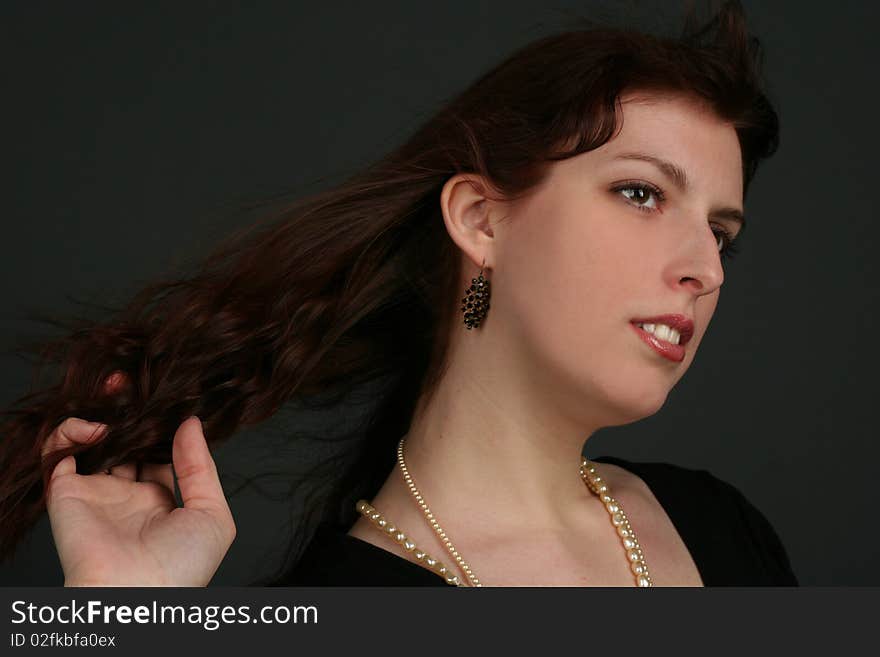 Portrait of young brunette woman isolated on black background