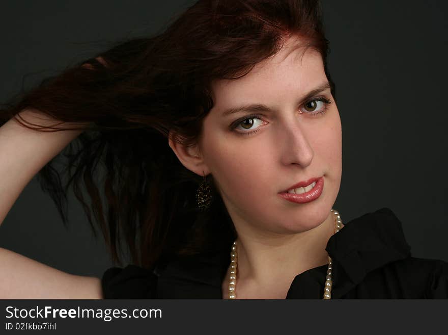 Portrait of young brunette woman isolated on black background