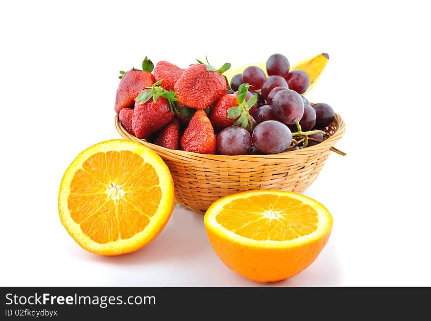 Fresh fruits in straw basket and two orange around. Fresh fruits in straw basket and two orange around