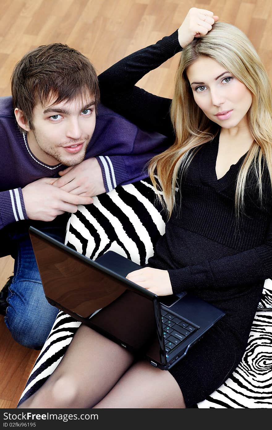 Young couple having a rest with a laptop at home.