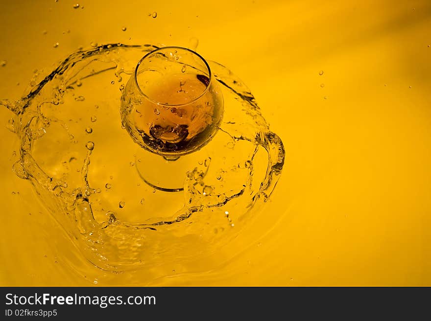 Class of brandy on creative brown background with water