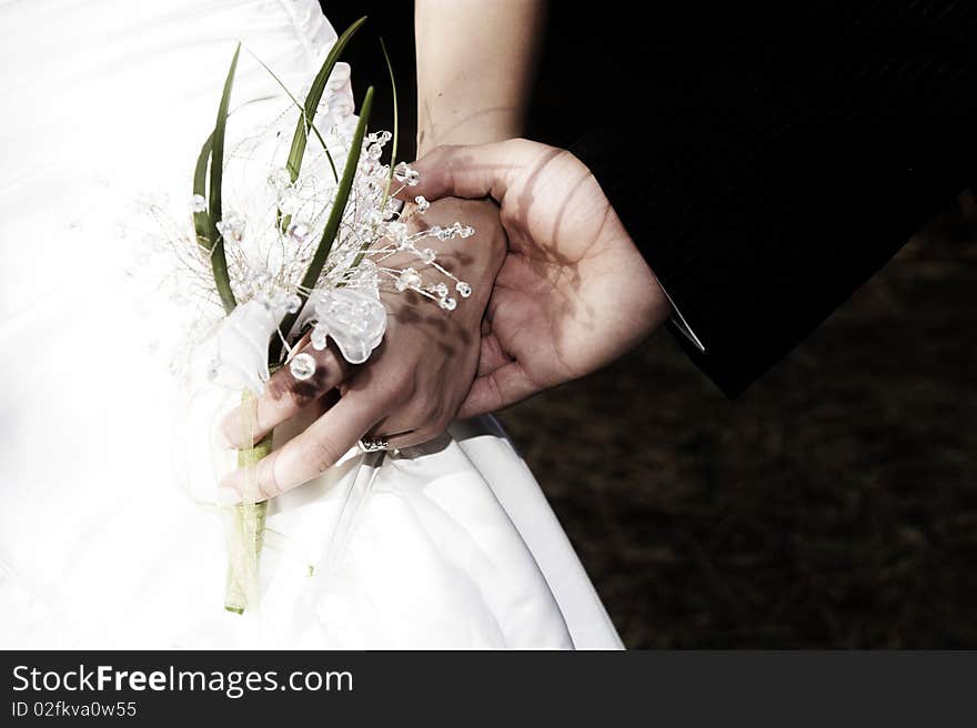 Groom holding his new bride's hand gently. Groom holding his new bride's hand gently